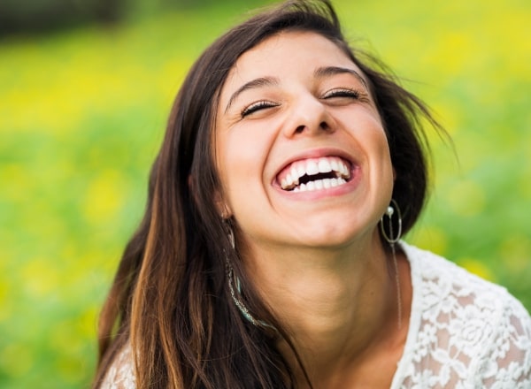 Woman smiling after all ceramic dental restorations