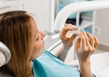 Patient holding clear aligner in treatment room