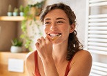 Woman smiling while brushing her teeth