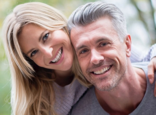 Man and woman with dentures smiling