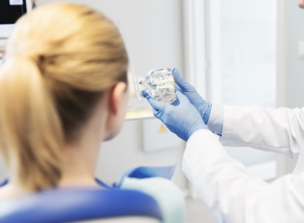 Dentist talking to dental patient during dental checkup and teeth cleaning visit