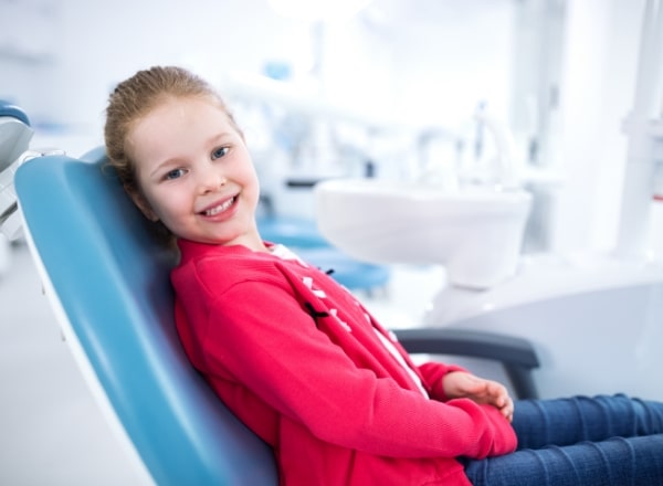 Young girl smiling during dental checkup and teeth cleaning visit