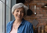 A cheery elderly woman posing indoors
