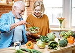 A cheerful senior couple eating salads together