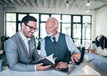 A senior businessman working with a younger one