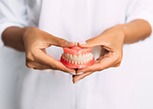 Lady presents viewer with dentures