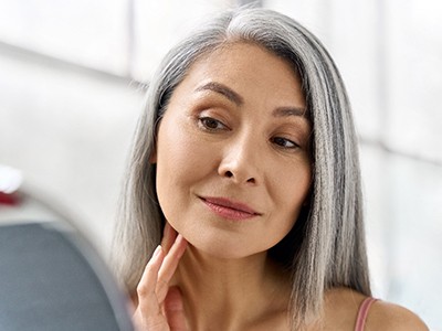 Denture patient in Phoenix looking in the mirror