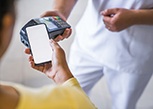 A patient using their phone to pay the cost of dentures