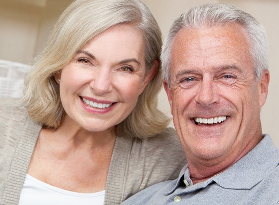Couple smiling after receiving their new dentures in Phoenix