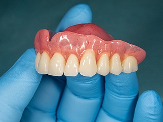 Dentist holding a full denture