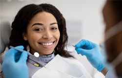 Woman smiling during checkup with dentist