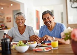 Couple smiling while eating meal at home