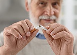 Closeup of man breaking cigarette