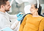 Smiling patient talking to dentist in treatment room