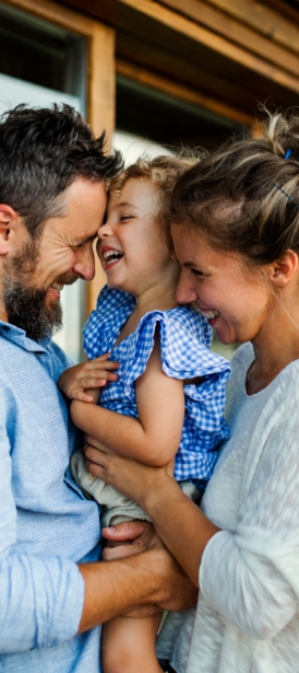 Mother and father holding child and smiling