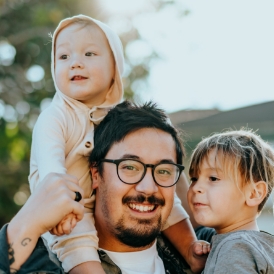 Father holding two young children