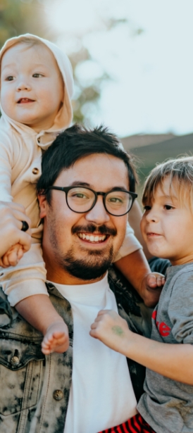 Father holding two young children