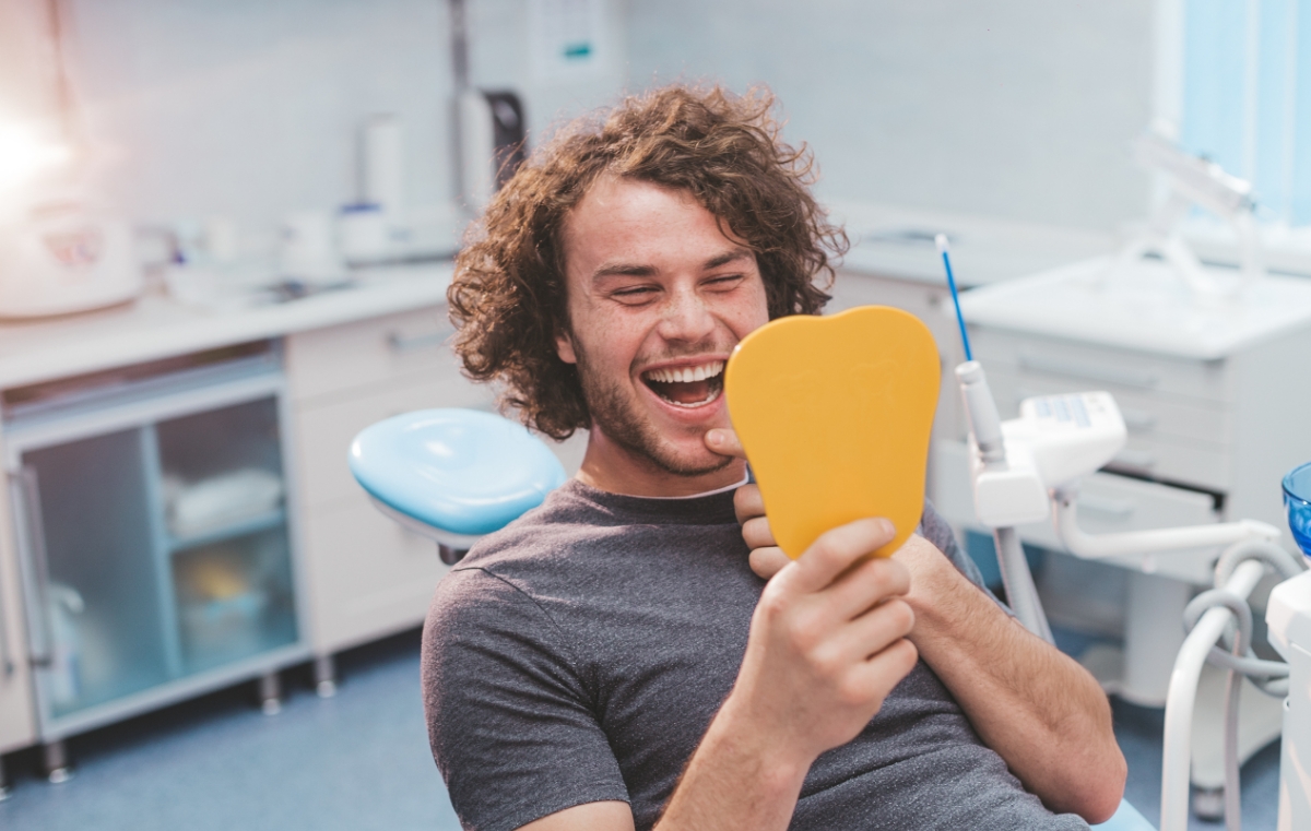 Man looking at smile after dental services