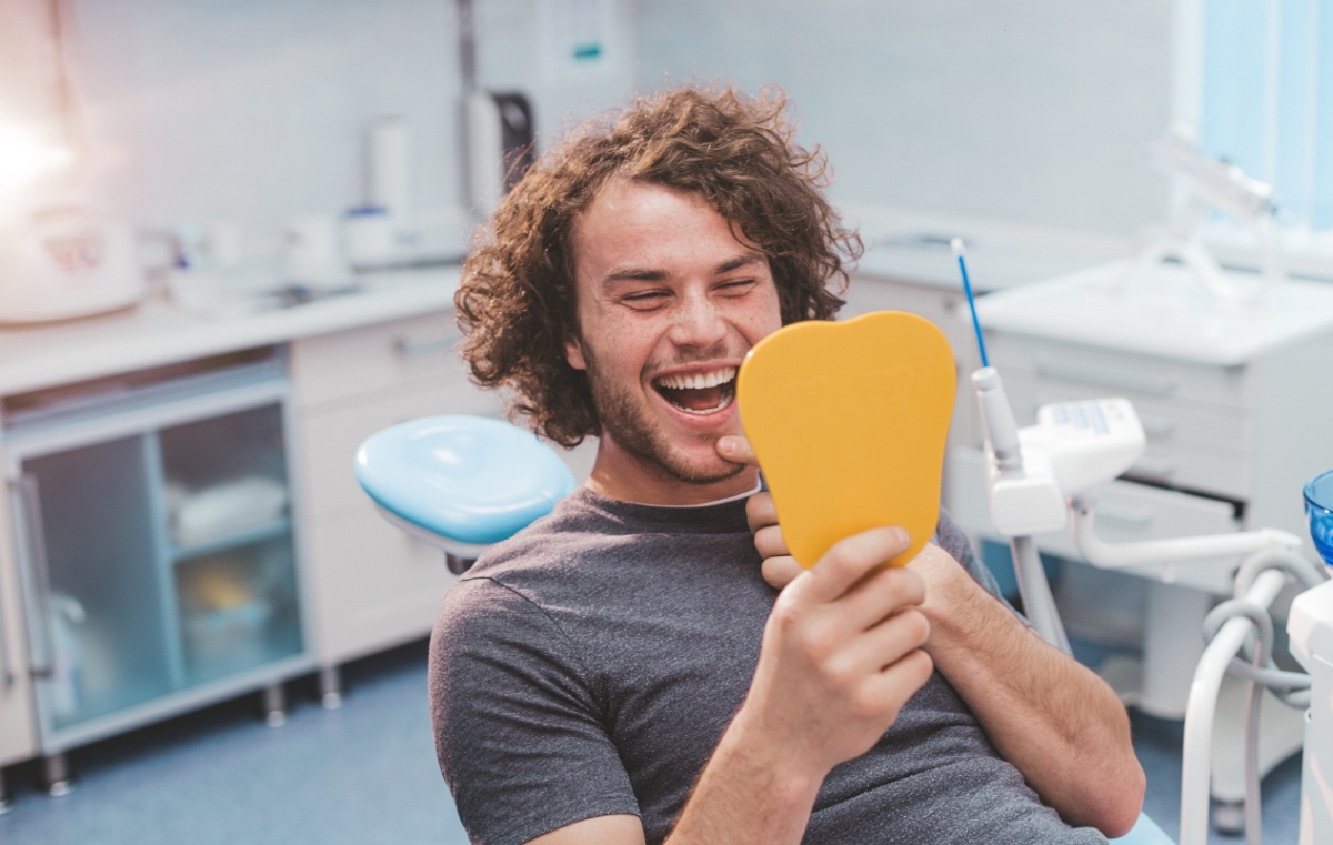 Man looking at smile after dental services