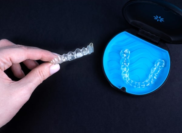 Person removing Invisalign tray from carrying case