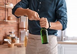 a man using a bottle opener on a bottle