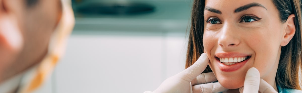 Dentist examining patient's smile after solea laser dentistry treatment