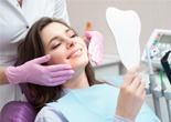 A woman admiring the results of cosmetic dentistry
