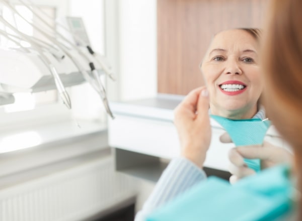 woman in red shirt trying on veneers 