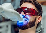 Man in dental chair having teeth professionally whitened