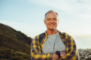 a retired person smiling with dental implant in Phoenix while on a hike