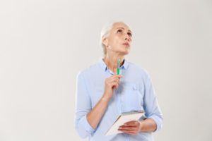 mature woman writing on a notepad