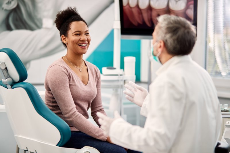 dentist answering questions about lifespan of dental implants