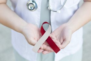 a dentist holding an oral cancer awareness ribbon