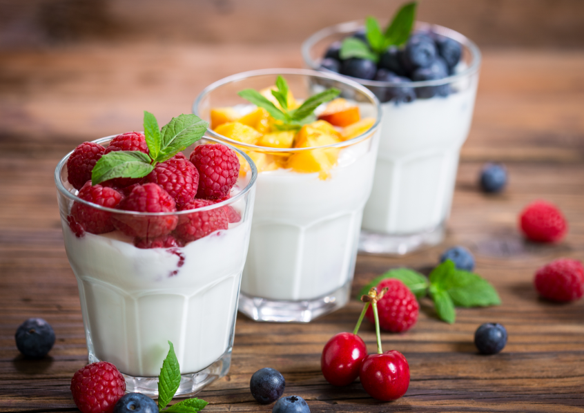 Three yogurt cups topped with fruit