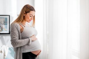 Pregnant woman holding her stomach. 